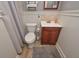 Compact half-bathroom with wainscotting, decorative mirror, and patterned tile flooring at 9001 East Carroll Rd, Winston, GA 30187