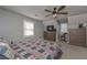 Comfortable bedroom featuring neutral walls, ceiling fan, dresser and a plaid comforter at 9001 East Carroll Rd, Winston, GA 30187