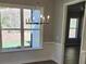 Bright dining area featuring a modern chandelier, a large window overlooking the yard, and access to the entry hall at 3032 Farm Tract Trl, Woodstock, GA 30189