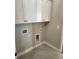 Laundry room features white cabinets and gray tile floors at 3032 Farm Tract Trl, Woodstock, GA 30189