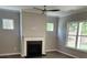 Cozy living room featuring a fireplace, hardwood floors, large windows overlooking the backyard, and neutral paint at 3032 Farm Tract Trl, Woodstock, GA 30189