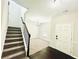 Inviting entryway with dark wood floors leading to a carpeted living area and staircase at 4417 Belcamp Rd, Fairburn, GA 30213