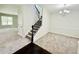 Bright living room featuring neutral carpet, a modern chandelier, and staircase at 4417 Belcamp Rd, Fairburn, GA 30213