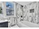 Modern bathroom featuring marble-look tile, black fixtures, and natural light from a window at 5292 Greenway Dr, Villa Rica, GA 30180