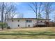 Back of home featuring a spacious backyard, white brick, small deck and blue skies at 1740 Starlight Dr, Marietta, GA 30062