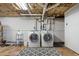 Basement laundry area with a front load washer and dryer, utility sink, and overhead plumbing at 1740 Starlight Dr, Marietta, GA 30062