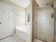 Bathroom with separate tub and shower, tile floors, and bright light from the window at 537 Autumn Ridge Dr, Canton, GA 30115