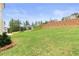 A spacious backyard area with lush green grass and a landscaped slope, perfect for outdoor activities and relaxation at 7525 Homer Dr, Cumming, GA 30028