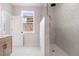 Modern bathroom featuring a glass enclosed shower with large tiles and a window with a neighborhood view at 7525 Homer Dr, Cumming, GA 30028