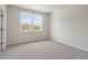 Bright bedroom with neutral carpet, two windows offering natural light, and a calming atmosphere at 7525 Homer Dr, Cumming, GA 30028