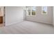 Bright bedroom with neutral carpet, two windows offering natural light, and a calming atmosphere at 7525 Homer Dr, Cumming, GA 30028