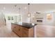 Spacious kitchen island with dark countertops and wood cabinets, connecting to an open living area at 7525 Homer Dr, Cumming, GA 30028