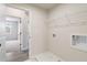 Bright laundry room with hookups, storage shelf, and gray wood-look flooring at 7525 Homer Dr, Cumming, GA 30028