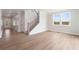 Open-concept living room with a staircase and light wood flooring at 7525 Homer Dr, Cumming, GA 30028