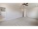 Large main bedroom with a ceiling fan and ensuite bathroom featuring neutral carpet and multiple windows at 7525 Homer Dr, Cumming, GA 30028