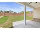Covered patio showcasing a concrete floor, white support columns, and views of the landscaped backyard at 7525 Homer Dr, Cumming, GA 30028