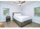 This bright bedroom features hardwood floors, a ceiling fan, and two windows for natural light at 2410 Macon Sw Dr, Atlanta, GA 30315