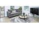 Comfortable living room with a plush gray sofa, stylish rug, and media center at 2410 Macon Sw Dr, Atlanta, GA 30315
