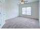 A carpeted bedroom is brightened by a window and ceiling fan at 5004 Duxford Se Dr, Smyrna, GA 30082