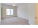 A bright carpeted bedroom with large window and door leading to other rooms at 5004 Duxford Se Dr, Smyrna, GA 30082