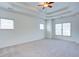 Large bedroom with plush carpet, multiple windows, and a tray ceiling at 5004 Duxford Se Dr, Smyrna, GA 30082