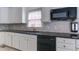 Kitchen counter with black appliances and white cabinets, and tile backsplash at 5004 Duxford Se Dr, Smyrna, GA 30082