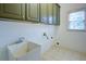 Well-lit laundry room features built-in cabinets, a utility sink, and a window at 5004 Duxford Se Dr, Smyrna, GA 30082