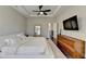 Spacious bedroom with tray ceiling, ceiling fan, and a large television at 373 Via Secco Ln, Suwanee, GA 30024