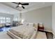 Spacious bedroom with tray ceiling, ceiling fan, dark hardwood floors, and sitting area near the window at 373 Via Secco Ln, Suwanee, GA 30024