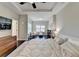 Spacious bedroom with tray ceiling, ceiling fan, dark hardwood floors, and sitting area near the window at 373 Via Secco Ln, Suwanee, GA 30024
