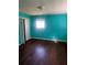 Bedroom with light shining through the window and vibrant turquoise walls needing renovation at 5430 Old Bill Cook Rd, Atlanta, GA 30349