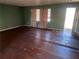 Living room with dark hardwood floors, and windows, needs work but has space and natural light at 5430 Old Bill Cook Rd, Atlanta, GA 30349