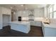 A kitchen boasts an island with bar seating, stainless steel appliances, and modern white cabinets at 574 Sawnee Village Blvd, Cumming, GA 30040