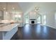 Bright open-concept living area featuring hardwood floors, fire place and white kitchen with island seating at 574 Sawnee Village Blvd, Cumming, GA 30040