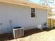 Side view of home with gray brick, AC unit, and partial yard view at 1546 Alverado Way, Decatur, GA 30032