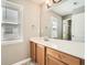 Bathroom with a large mirror, window, light wood cabinets, and white countertop at 5430 Falls Landing Dr, Cumming, GA 30040