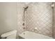 Close-up of a neutral tile shower and tub, with showerhead and faucet at 5430 Falls Landing Dr, Cumming, GA 30040