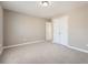 This bedroom features neutral walls, carpet flooring, closet, and two doors at 5430 Falls Landing Dr, Cumming, GA 30040