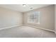 This bedroom features neutral walls, carpet flooring, and a window for natural light at 5430 Falls Landing Dr, Cumming, GA 30040