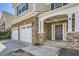 Inviting front porch with stone accents and a two-car garage at 5430 Falls Landing Dr, Cumming, GA 30040