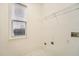 A simple laundry room with white tile floor, window, and utility connections at 5430 Falls Landing Dr, Cumming, GA 30040