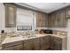 Kitchen featuring granite countertops, dark cabinets, stainless steel sink, and mosaic backsplash at 801 Hemingway Rd, Stone Mountain, GA 30088
