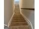 Carpeted staircase featuring wooden handrail and a white wall provides access to upper levels at 5305 Tolar Rd, South Fulton, GA 30213