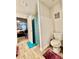 A clean bathroom features a shower with a blue curtain, complemented by colored mats on the light wood flooring at 1367 Midnight Ride Ct, Hampton, GA 30228