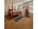 Spacious bedroom featuring a four-poster bed, rocking chair, and natural light from two windows at 1367 Midnight Ride Ct, Hampton, GA 30228