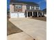 Two-story home featuring a two-car garage, brick facade, and a covered front porch with stately columns at 1367 Midnight Ride Ct, Hampton, GA 30228