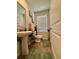 Charming half bath with pedestal sink, stylish decor, and hardwood floors at 1367 Midnight Ride Ct, Hampton, GA 30228