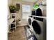 Well-organized laundry room with modern washer and dryer, shelving, and natural light at 1367 Midnight Ride Ct, Hampton, GA 30228