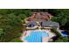 Aerial view of a community pool and tennis courts surrounded by lush greenery and other neighborhood amenities at 2869 Amesbury Nw, Kennesaw, GA 30144
