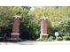 Community entrance with brick columns, a decorative Legacy Millwork sign, and mature landscaping at 2869 Amesbury Nw, Kennesaw, GA 30144